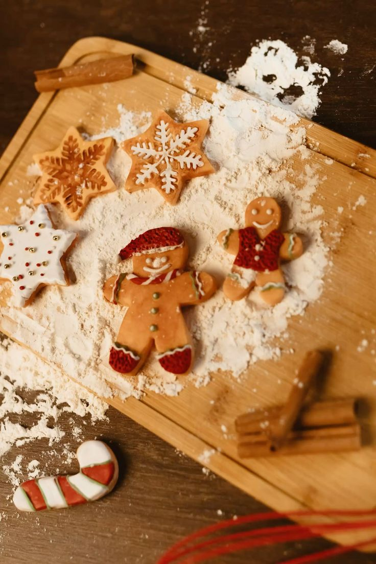 Biscoitos natalinos decorados sobre uma mesa enfarinhada